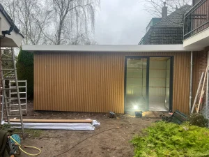 Chalet bekleden met composiet in teak kleur – verticale montage, project Groningen